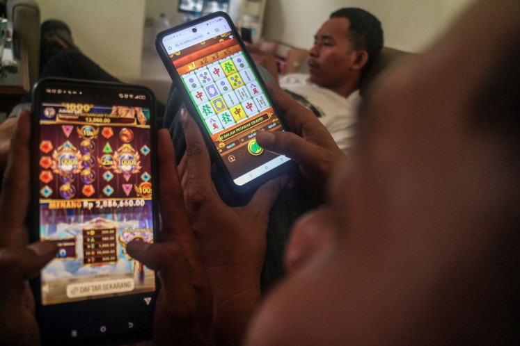 People use smartphones on May 30, 2024 in Bogor, West Java, to access online gambling websites.
