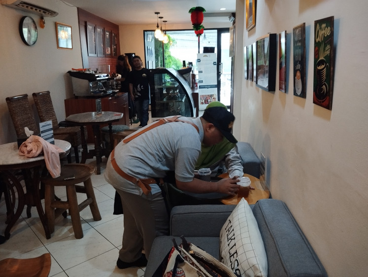 Friendly service: Arik serves coffee to a customer on May 2, 2024. People with Down's syndrome are able to work and be independent if society gives them a chance. 