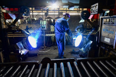 An employee works on a production line at a car wheel rim factory in Qingzhou in eastern China's Shandong province on June, 17 2024.