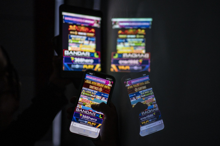 Advertisements for online gambling websites are displayed on smartphone screens on June 19, 2024, in Jakarta.