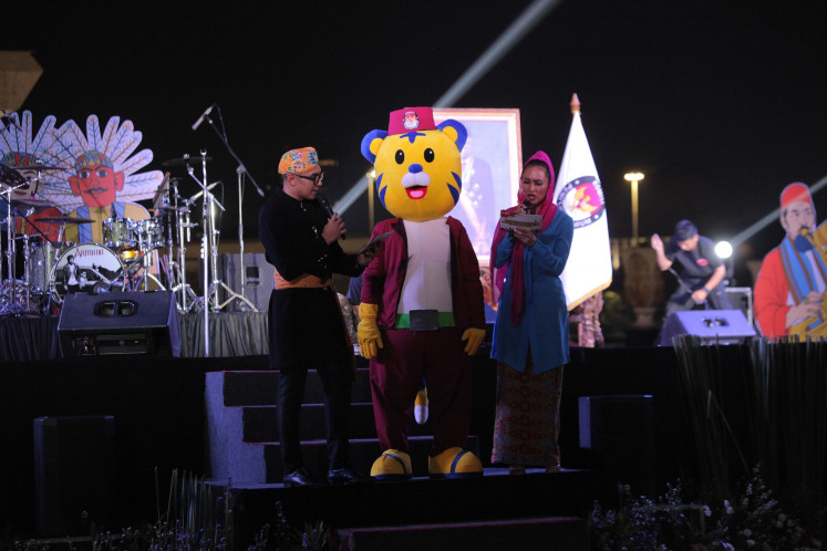 Emcees stand with Si Mayor, the mascot for the 2024 Jakarta gubernatorial election, on the stage during the election's launch at the National Monument (Monas) in Jakarta on May 25, 2024.