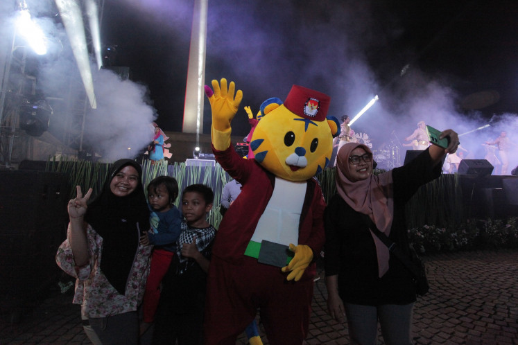 Visitors take a selfie with Si Mayor, the mascot for the 2024 Jakarta gubernatorial election, during the launch of the election mascot at the National Monument (Monas) Square in Jakarta on May 25, 2024.