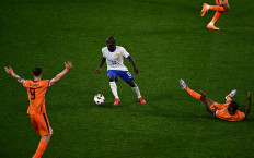 France's midfielder #13 N'golo Kante (center) controls the ball past Netherlands' forward #09 Wout Weghorst and midfielder #08 Georginio Wijnaldum during the UEFA Euro 2024 Group D football match between the Netherlands and France at the Leipzig Stadium in Leipzig on June 21, 2024. 