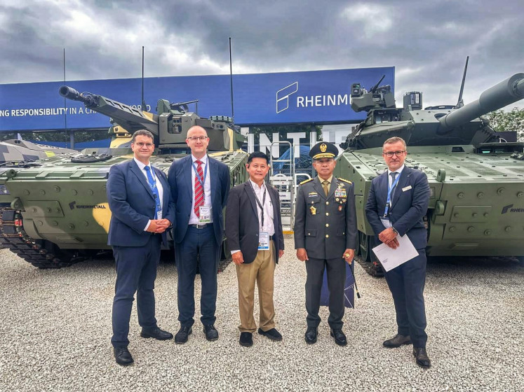 Indonesian Military (TNI) commander Gen. Agus Subiyanto (second right) poses with representatives of German weapon maker Rheinmetall on June 19, 2024, during the Eurosatory 2024 defense exhibition at the Paris Nord Villepinte Exhibition Center in Paris. Rheinmetall showcased, among other things, the Lynx KF41 infantry fighting vehicle (background left) and the Lynx 120 combat support vehicle (background right) at the exhibition. 