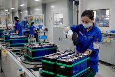 Employees work at a factory that produces lithium battery for export in Huaibei, in eastern China's Anhui province, on June 11, 2024.