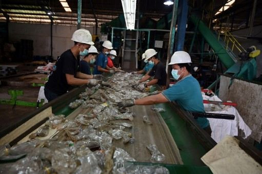 Workers sort plastic mineral water bottles at a plastics recycling factory in Tangerang, Banten, on Aug. 5, 2022.

