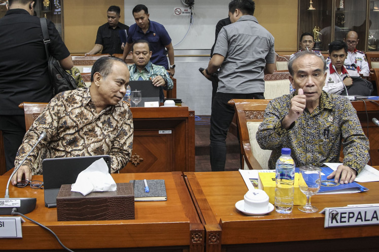 Communications and Information Minister Budi Arie Setiadi (left) looks at National Cyber and Encryption Agency (BSSN) head Hinsa Siburian (right), who gives a thumb up toward reporters, ahead of a meeting about the recent ransomware attack on the temporary National Data Center facilities with House of Representatives Commission 1 overseeing communications and information at the Senayan legislative complex in Jakarta on June 27, 2024.