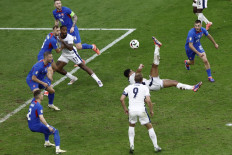 England's midfielder #10 Jude Bellingham shoots and scores his team's first goal during the UEFA Euro 2024 round of 16 football match between England and Slovakia at the Arena AufSchalke in Gelsenkirchen on June 30, 2024. 