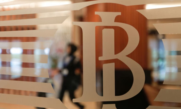Behind the scenes: A woman walks past the logo of Bank Indonesia in Jakarta on Nov. 17, 2016. 
