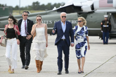 US President Joe Biden and First Lady Jill Biden, along with granddaughters Natalie (left) and Finnegan (2nd left), walk from Marine One to board Air Force One at Francis S. Gabreski Airport in Westhampton Beach, New York on June 29, 2024. 