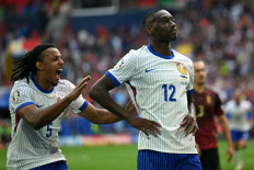 France's forward #12 Randal Kolo Muani (R) celebrates scoring his team's first goal during the UEFA Euro 2024 round of 16 football match between France and Belgium at the Duesseldorf Arena in Duesseldorf on July 1, 2024. 