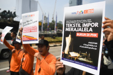 Workers join a rally at in Central Jakarta on July 3, 2024, demanding companies stop
laying off textile industry workers