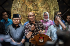 General Elections Commission (KPU) chairman Hasyim Asy'ari (center, front row), accompanied by KPU commisisoners Idham Holik (right, front row) and Mohammad Afifuddin (left, front row), gives a press statement at the KPU headquarters in Jakarta on July 3, 2024 in response to an Election Organization Ethics Council (DKPP) decision to order his dismissal. The DKPP has sacked Hasyim over the sexual harassment of an Overseas Election Committee (PPLN) member.