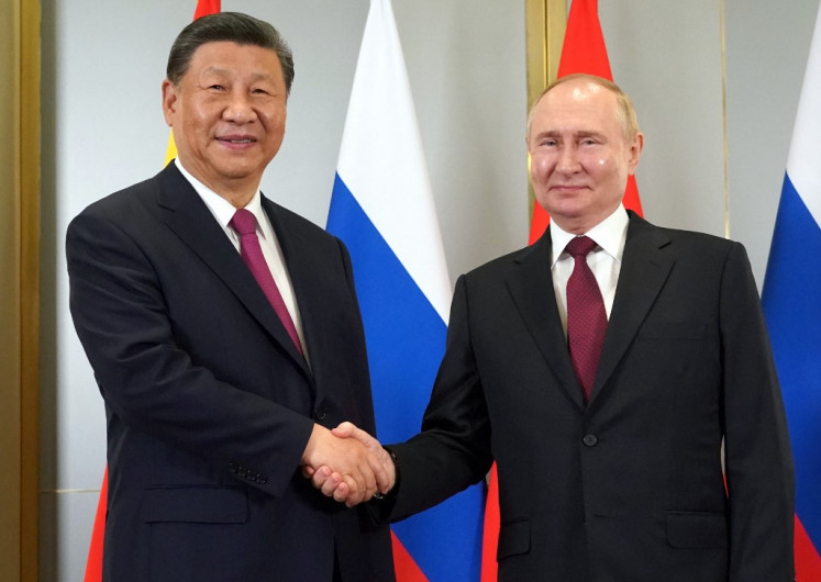 In this pool photograph distributed by the Russian state agency Sputnik, Russia's President Vladimir Putin meets with China's President Xi Jinping on the sidelines of the Shanghai Cooperation Organisation (SCO) member states leaders' summit in Astana on July 3, 2024. 