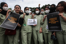 Young physicians hold posters during a demonstration on July 4, 2024, in front of Airlangga University's medical school in Surabaya, East Java. During the protest, which was also attended by professors and other academics on campus, they demanded that university rector Mohammad Nasih reinstate Budi Santoso as the dean of the school so he could complete his term. Budi was dismissed after disagreeing with the Health Ministry's plan to invite foreign doctors to practice in Indonesia.