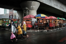 Street food carts are seen under a railway bridge after the rain on Feb. 5, 2024, in Jakarta.