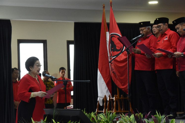 Indonesian Democratic Party of Struggle (PDI-P) chairwoman Megawati Soekarnoputri (left) reads aloud the oath for newly inaugurated party officials at the PDI-P's headquarters in Lenteng Agung, South Jakarta on July 5, 2024. Among the newly inaugurated officials are former Central Java governor Ganjar Pranowo and former Jakarta governor Basuki “Ahok“ Tjahaja Purnama.