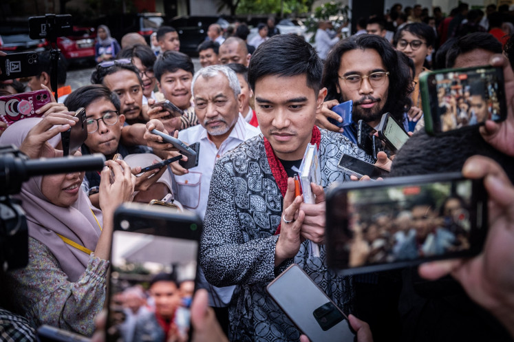 Indonesian Solidarity Party (PSI) chair Kaesang Pangarep (center right), accompanied by Prosperity Justice Party (PKS) chair Ahmad Syaikhu (center left), wades through a crowd of reporters on July 8, 2024 as he arrives at the PKS headquarters in Jakarta.