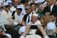 A large crowd of people surrounds Pope Francis on July 7, 2024 as he arrives at the Piazza dell'Unita in Trieste during the 50th Social Week of Italian Catholics.