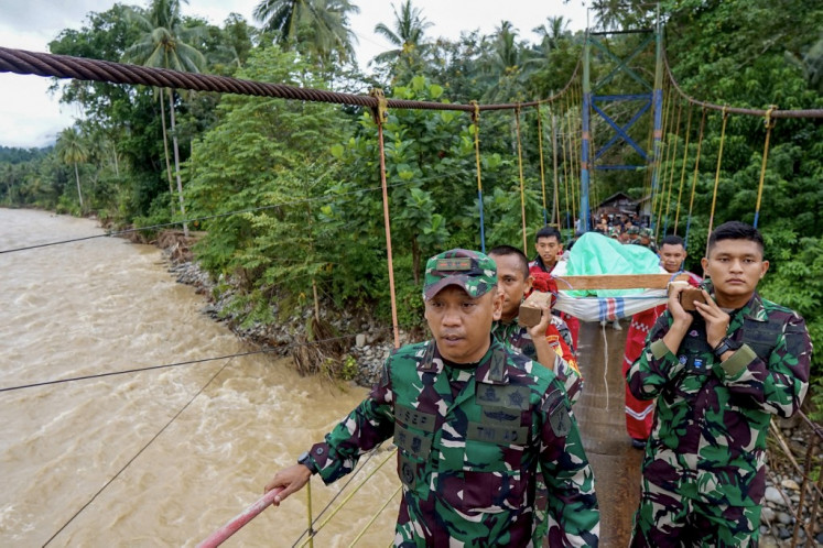 Members of a rescue team carry a survivor of the landslide at Tulabolo village in Bone Bolango Regency of the Gorontalo Province on July 8, 2024. At least 11 people are dead and 19 more are missing after heavy rains caused a landslide near an illegal gold mine on Indonesia's central island of Sulawesi, an official said July 8.