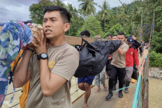 Members of a rescue team carry a victim who died in a landslide at Tulabolo village in Bone Bolango Regency of the Gorontalo Province on July 9, 2024. 