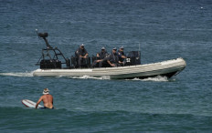 Armed police from the elite Special Operations Group patrol off the coast of north Cronulla Beach in Sydney, 18 December 2005. 