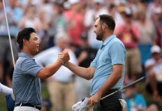 South Korea’s Tom Kim (left) shakes hands with the United States’ Scottie Scheffler on June 23 during a one-hole playoff in the final round of the Travelers Championship 2024 at TPC River Highlands in Cromwell, Connecticut. Scheffler went on to beat Kim to win the PGA Tour tournament.