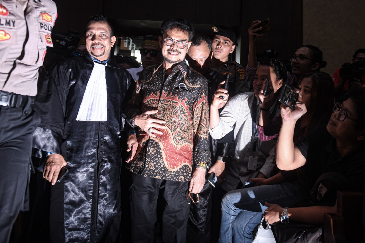 Former agriculture minister Syahrul Yasin Limpo (center) enters the courtroom ahead of the verdict hearing against him at the Jakarta Corruption Court in Jakarta on July 11, 2024. A panel of judges finds him guilty of soliciting bribes and accepting gratuities from his colleagues at the Agriculture Ministry, punishing him with a 10-year imprisonment, a Rp 300 million fine as well as Rp 14.1 trillion and US$30,000 in restitutions.