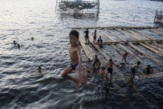 A boy jumped into the sea of Cilincing, Jakarta, on June 6, 2020. A number of children living around the area played in the embankment area even though the action could endanger safety. 