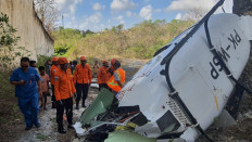 Authorities remove helicopter wreckage in Bali as survivors look on