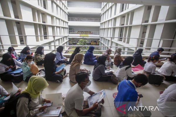 Senior high school graduates sit in line on May 8, 2023 as they wait to take a national state university admissions test at the University of Indonesia in Depok, West Java.