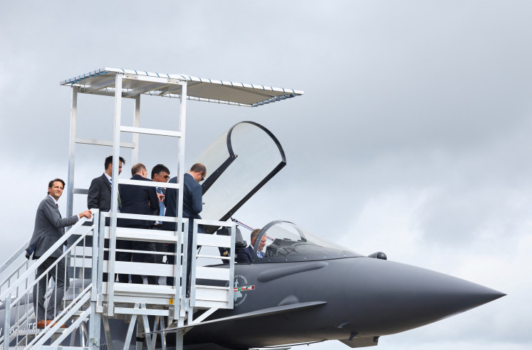 Attendees queue to sit in the cockpit of a Eurofighter Typhoon jet fighter at the Farnborough International Airshow, in Farnborough, England, on Monday, July 22, 2024. The biennial airshow runs until Friday