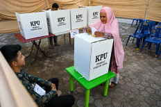 A woman casts her ballot during a revote due to logistical issues in the general election in Banda Aceh on Feb. 22, 2024.