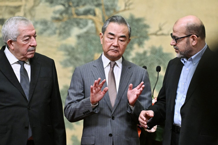 Mahmoud al-Aloul, Vice Chairman of the Central Committee of Palestinian organization and political party Fatah, China's Foreign Minister Wang Yi, and Mussa Abu Marzuk, senior member of the Palestinian Islamist movement Hamas (left to right), attend an event at the Diaoyutai State Guesthouse in Beijing on July 23, 2024. China's Foreign Minister Wang Yi on July 23 hailed an agreement by 14 Palestinian factions to set up an “interim national reconciliation government“ to govern Gaza after the war.