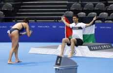 Palestinian swimmer Yazan al-Bawwab poses with a Palestinian flag on the podium before training ahead of the Paris 2024 Olympics at the Paris La Defense Arena in Nanterre, Paris, on Tuesday, July 23, 2024. 