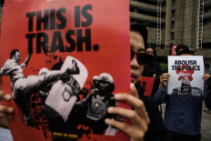People hold up posters during a demonstration against police violence on July 18, 2024 in Bandung, West Java.
