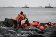 A coast guard personnel arranges an oil spill containment boom to be on standby for deployment at a port in Limay, Bataan on July 25, 2024. 