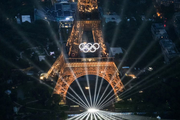 A photograph taken from a helicopter on July 26, 2024 shows an aerial view of the Eiffel Tower and the Olympics Rings lightened up during the opening ceremony of the Paris 2024 Olympic Games in Paris.