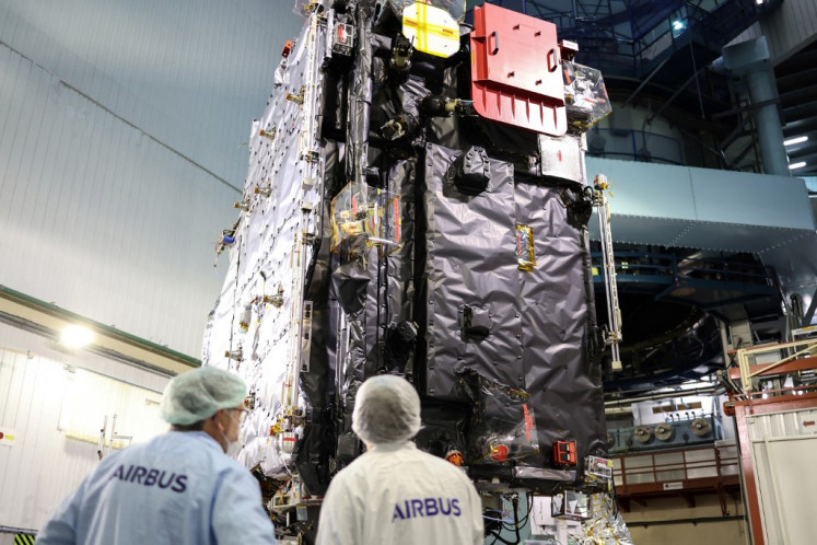 Engineers work around the ESA's (European Space Agency) “Juice“ probe during its unveiling for media in Toulouse, southwestern France on January 20, 2023, a few days ahead of its departure to Kourou space center. A spacecraft that launched in April 2023 will slingshot back around Earth and the Moon in August 2024 in a high-stakes, worlds-first maneuver as it pinballs its way through the Solar System to Jupiter.