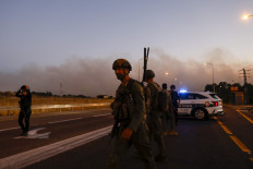 Israeli soldiers and police secure a road as rockets are launched from southern Lebanon in the Israeli-annexed Golan Heights on July 9, 2024, amid ongoing cross-border clashes between Israeli troops and Hezbollah fighters.