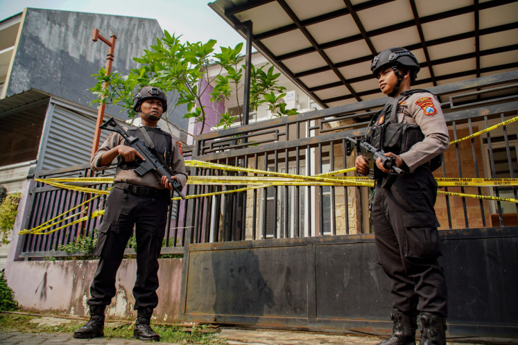 Police officers stand guard on Aug. 1, 2024, at a house used by a terror suspect in Batu, East Java.