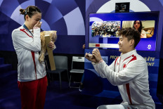 China's Gold medalist Huang Ya Qiong (left) reacts as she receives a marriage proposal from her partner Liu Yuchen after leaving the podium at the mixed doubles badminton medal ceremony during the Paris 2024 Olympic Games at Porte de la Chapelle Arena in Paris on Aug. 2, 2024.