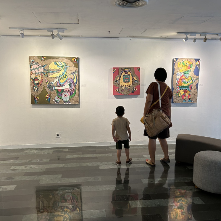 Spellbound: A mother and her son stand transfixed by Let’s Sing Together, Magic Mushroom and I’m A Dog Face during an exhibition at Artotel Thamrin in Central Jakarta on May 9, 2024 . Artist Antonius Kho’s "Love Robots" exhibition explored the relationship between humanity and robots as well as other technology in a whimsical light.
