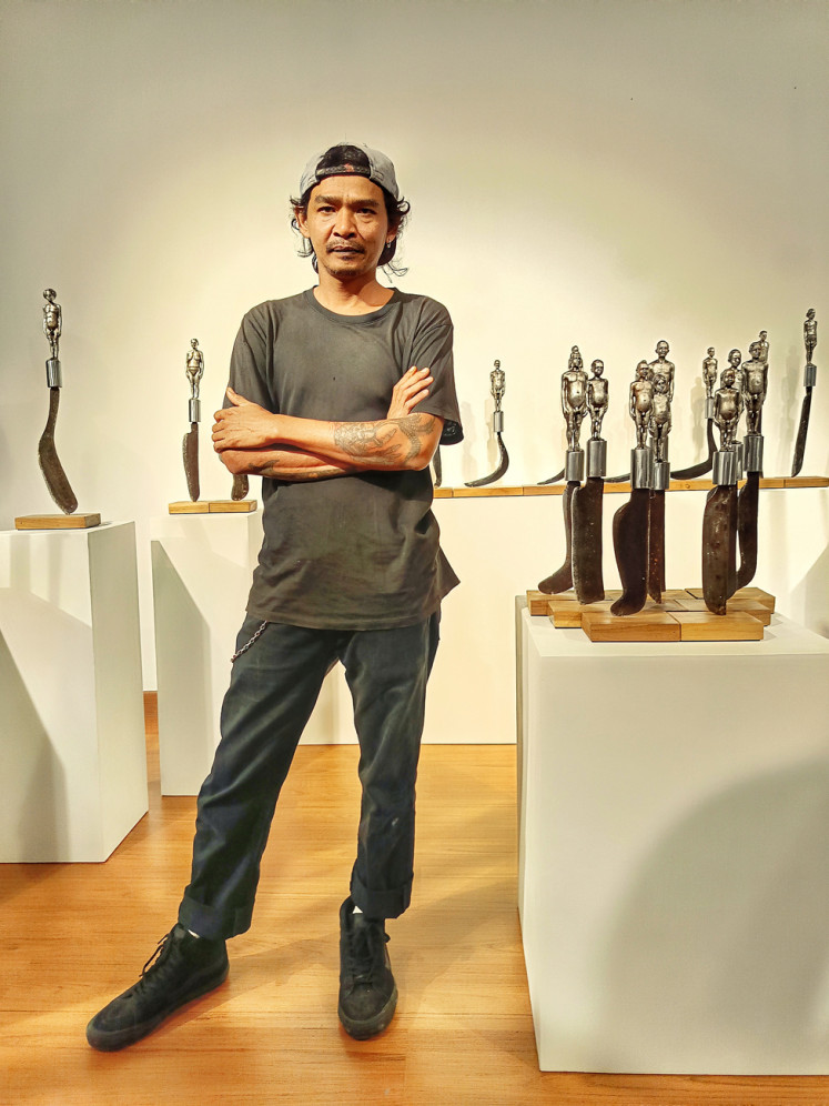 Images of the past: Budi Santoso stands in front of his work 