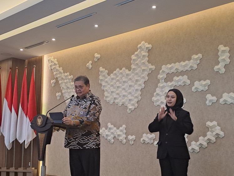 Coordinating Economic Minister Airlangga Hartarto (left) and his interpreter (right) stand before the press in his Jakarta office on Aug. 5, 2024, to answer questions about Indonesia's gross domestic product growth in the second quarter of 2024.