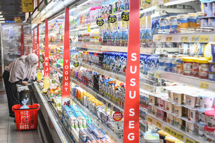 A customer picks a bottled beverage from a refrigerated display on July 5, 2024, at a supermarket in South Tangerang, Banten.