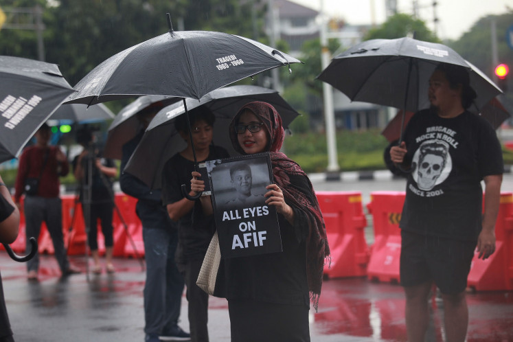 Several Kamisan (Thursday) silent protesters holds posters on July 4, 2024, during a protest in Jakarta  demanding a thorough investigation into the death of AM, a 13-year-old boy who was allegedly beaten to death by police officers after being suspected of inciting a brawl in Padang, West Sumatra.