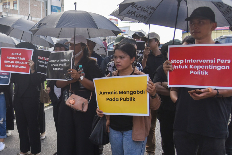 Protesters hold posters when attending a solidarity protest at the North Sumatra Police in Medan, North Sumatra on July 25, 2024, over the death of Rico Sempurna Pasaribu, who died with his family in an alleged arson attack in Karo regency, North Sumatra.