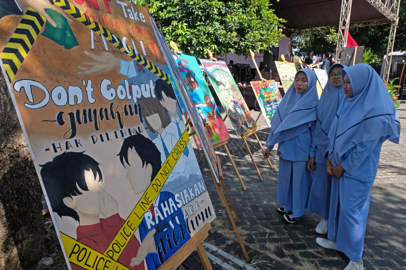 A group of women looks at posters encouraging people to vote in this year’s regional head elections, displayed on Aug. 5, 2024 at an event in Temanggung, Central Java.