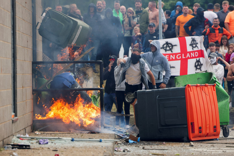 Protestors throw a garbage bin on fire outside a hotel in Rotherham, Britain, August 4, 2024. REUTERS/Hollie Adams 